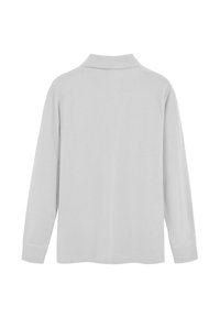 Ljusgrå långärmad polo med flat krage och knappslå. Slät tygtextur med skräddarsydd passform och sidsprickor i nederkanten.