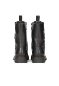 Botas de tobillo de cuero negro con textura suave, cremalleras laterales y un detalle de logo. Suelas de goma resistentes que proporcionan durabilidad y agarre.
