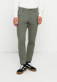 Pantalons cargo en vert olive, en coton, avec des poches latérales, une coupe droite et une fermeture à bouton à la taille.