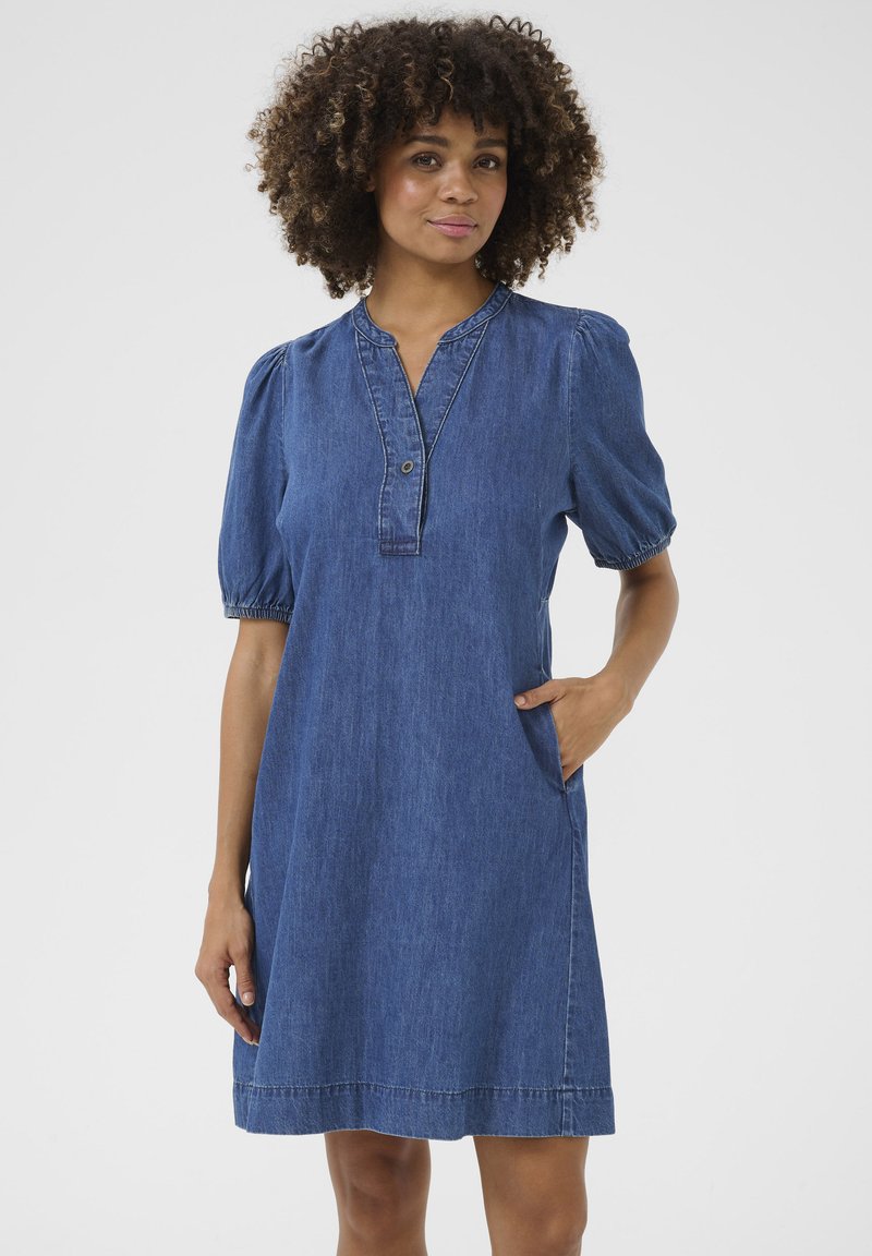 Denim dress with a collared neckline, short puff sleeves, and side pockets. Features a solid blue color and contrast stitching accents.