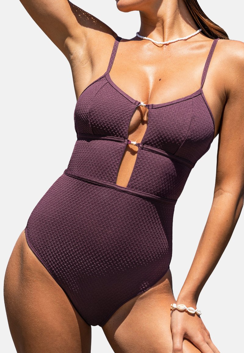 Maillot de bain une pièce bordeaux avec un motif texturé, des bretelles réglables et un détail découpé au niveau du buste. Il présente un design à rayures.