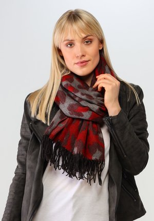 Roter und grauer gemusterter Schal aus weichem Stoff, mit Fransenverzierung an den Enden, um den Hals des Models gewickelt.