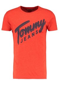 Czerwona bawełniana koszulka z krótkim rękawem, z dużym niebieskim nadrukiem "Tommy Jeans" na piersi. Klasyczny krój z okrągłym dekoltem.
