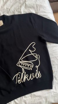 Sweat-shirt noir avec un design brodé blanc représentant un gramophone et le mot "Folkviz". Le tissu semble doux avec des poignets et un ourlet côtelés.