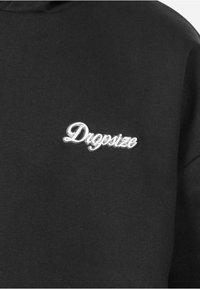 Czarna bluza z przywieszką w kolorze srebrnym z wyszywanym logo "Dropsize" na klatce piersiowej. Wykonana z miękkiego materiału o gładkiej fakturze.
