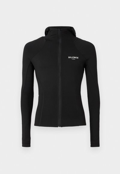 Camiseta negra de manga larga con cremallera, hecha de un material suave y elástico. Presenta un alto cuello y un pequeño logo de "SILENCE" en la parte delantera.