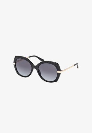 Black sunglasses with oversized frames, gradient dark lenses, textured black detailing on the top, and gold accent on the sides.