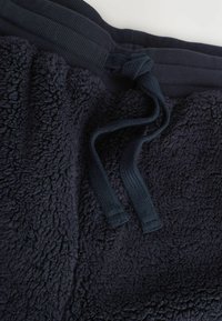 Marineblå fleece joggers med en blød, struktureret overflade, der har en ribbet talje og en knyttet snor.