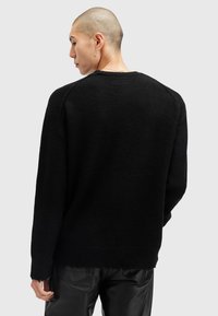 Sort sweater lavet af tekstureret stof, med en ribbet halslinning og en ufuldstændig nederkant, med en afslappet pasform og dropped skuldre.