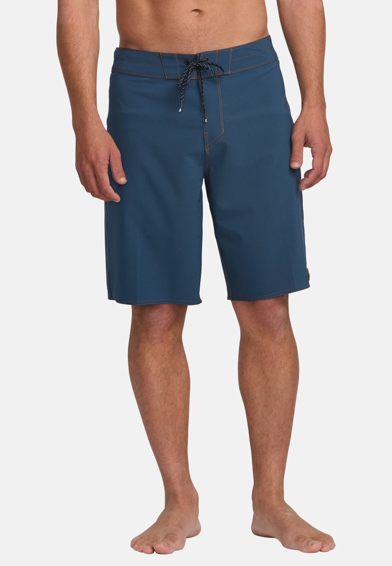 Pantaloni corti blu con vita regolabile tramite cordino, cuciture a contrasto, logo inciso e lunghezza fino a metà coscia. Realizzati in tessuto a asciugatura rapida.