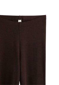 Mörkbruna leggings med en slät yta och ett enkelt elastiskt midjeband. Har en söm på baksidan och en liten etikett nära toppen.