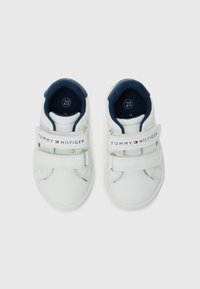 Hvite sneakers med marineblå detaljer, laget av lær, med doble borrelåsremmer og en logorem med røde og blå detaljer. Størrelse 20.