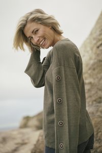 Olive green sweater with a relaxed fit, featuring long sleeves and large buttons along the side. Soft texture, designed for comfort.