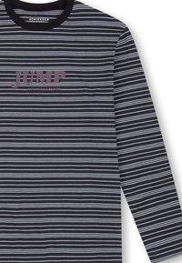 Langärmliges T-Shirt in Dunkelblau mit weißen und hellblauen horizontalen Streifen. Auf der Brust steht das Wort "JUMP" in Lila.