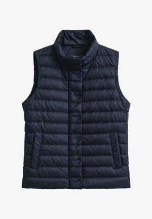 Temno modra puhasta brezrokavnik z lijakastim ovratnikom, zapiranjem na gumbe, dvema stranskima žepoma in prešito teksturo. Na prsih je diskretna blagovna znamka.