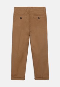 Bruna bomullsbukser med rak passform, utrustade med två bakfickor med knappstängning och uppvikta fållar för en skräddad look.