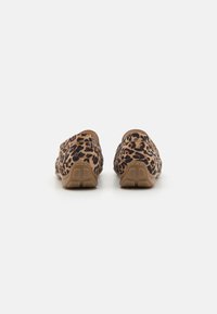 Leopardų rašto slip-on batai su minkšta audinio viršumi ir tekstūruotu smėlio spalvos padu. Yra suapvalinta nugarėlė ir žemo profilio dizainas.