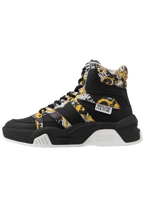 Czarny sneaker typu high-top z grubą białą podeszwą, ozdobiony złotymi i białymi barokowymi kwiatowymi wzorami oraz oznaczeniem "Versace Jeans Couture".