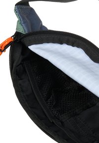 Πολύχρωμο νεσεσέρ με μαύρο φερμουάρ, που διαθέτει διχτυωτή θήκη και εσωτερική επένδυση φωτεινού μπλε με σχέδιο πλέγματος. Ανθεκτικό ύφασμα και ενισχυμένες ραφές.