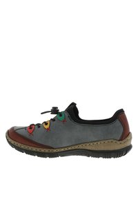 Chaussure en suède gris avec des accents rouges, motif en superposition semblable à des lacets avec des boucles colorées, et une semelle en caoutchouc texturée beige. Bout rond et profil bas.