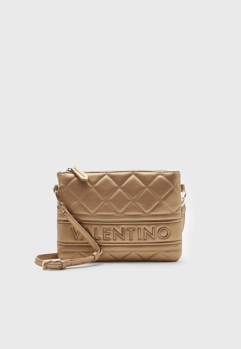 Prošívaná béžová kožená crossbody kabelka s vyraženým logem "Valentino", obdélníkový tvar, nastavitelný popruh a zipové uzavření.