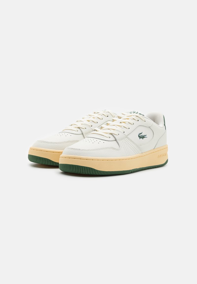 Baskets blanches en cuir avec une finition texturée, semelle en caoutchouc verte, semelles intermédiaires beiges et accents de logo verts. Présente un design classique à lacets.