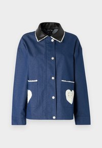 Navy denim jacket with a black faux leather collar, white scalloped trim, and two front pockets featuring heart-shaped crochet details.