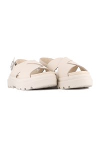 Lys beige sandaler med kryssremdesign, sølvspenne, tykk teksturert såle og åpen hæl for pusteevne.