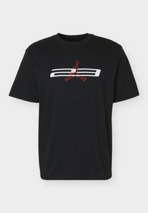 T-shirt noir à manches courtes avec un logo de joueur de basket-ball blanc et rouge centré sur la poitrine.