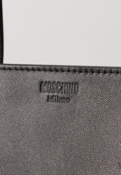 Black leather handbag featuring a textured surface, embossed "Moschino Milano" logo, and detailed stitching along the edges.