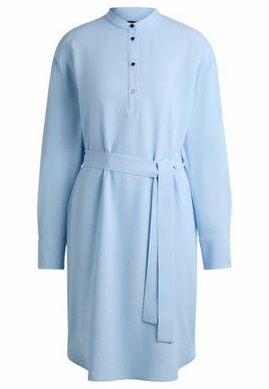 Light blue shirt dress with long sleeves, a stand collar, and a button placket featuring three black buttons. Includes a tied waist belt.