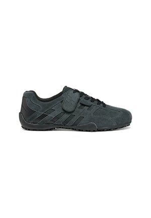 Zapatilla de ante gris oscuro con cordones negros, suela de goma y una etiqueta con la inscripción "The Original Snake" pegada a los cordones en el lateral.
