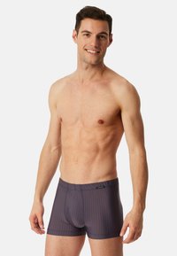 Navy and orange striped boxer briefs, made of stretchy fabric, feature an elastic waistband and a snug fit. Smooth texture, tailored design.