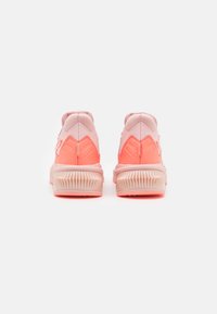 Zapatillas deportivas con un diseño en rosa y coral, parte superior sintética, cuello acolchado y suela de goma texturizada. Acentos desvaídos mejoran el interés visual.