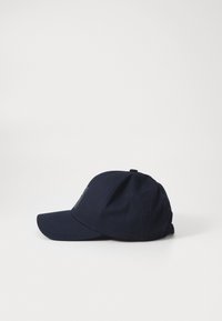 Sötétkék baseball sapka ívelt karimával, pamutból készült, elöl hímezett logóval és hátul állítható pánttal.