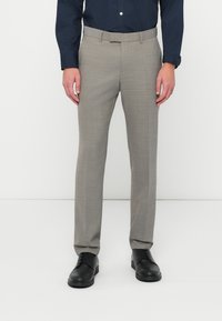 Ανοιχτό γκρι κομμένα παντελόνια με υφή ύφανσης, επίπεδο μπροστινό μέρος, θηλιές ζώνης και σλιμ φιτ, συνδυασμένα με μαύρες δερμάτινες παπούτσια.