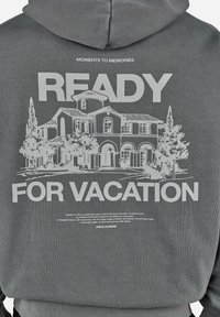 Szara bluza z kapturem z grafiką dużego domu, drzew oraz tekstem "Moments to Memories READY FOR VACATION" na plecach.