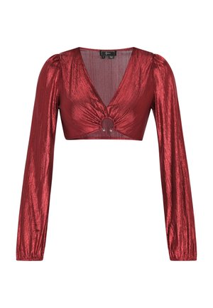 Top rosso corto con scollatura a V profonda, maniche lunghe a sbuffo e dettaglio centrale a cerchio. Realizzato in tessuto lucido con finitura testurizzata.