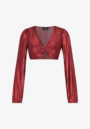 Top scurt roșu cu decolteu adânc în V, mâneci lungi tip puff și detaliu central în formă de inel. Fabricat dintr-un material lucios cu o textură interesantă.