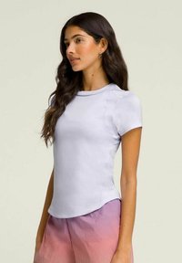 Camiseta corta de manga corta en lavanda claro con escote redondeado y hombros sin costuras, combinada con pantalones cortos ombre rosa, textura suave.