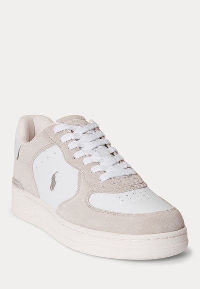 Μπεζ και λευκό sneaker χαμηλού ύψους με λευκά κορδόνια, διάτρητη μύτη, σουέντ λεπτομέρειες και μικρό ραμμένο λογότυπο στην πλευρική επιφάνεια.