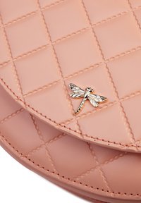 Borsa a tracolla rosa trapuntata in materiale liscio, con un accento a forma di libellula in tono oro e dettagli di cucitura intricati.