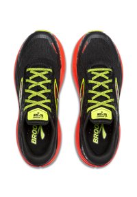 Melnas skriešanas kurpes ar elpojošu acu augšdaļu, dzīvīgu zaļu auklu un sarkanu zoli ar reflektējošiem akcentiem.