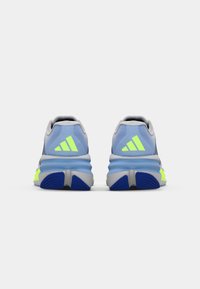 Des baskets de course bleues et grises avec des accents réfléchissants, une tige texturée et une semelle intermédiaire épaisse avec des touches de jaune fluo.