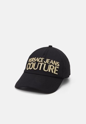Casquette de baseball noire avec un grand texte brodé en or "VERSACE JEANS COUTURE" sur la partie avant.
