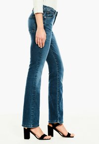 Jeans de mezclilla azul claro con un diseño de pierna recta, que presentan una cintura de altura media, costuras visibles y un dobladillo con un borde ligeramente deshilachado.