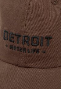 Brown fabric cap with black embroidered text "DETROIT MOTOR LIFE" on the front panel.
