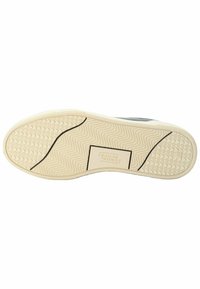 Shoe sole in rubber, cream-colored with patterned traction. Features black line accents and brand name text. Flat, rounded shape.