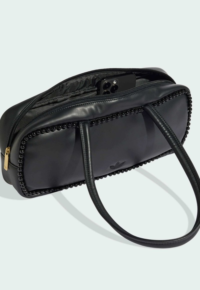 Borsa a mano in pelle nera con rifinitura di perline, cerniera aperta che rivela uno smartphone nero all'interno e doppi manici a tracolla su uno sfondo chiaro.