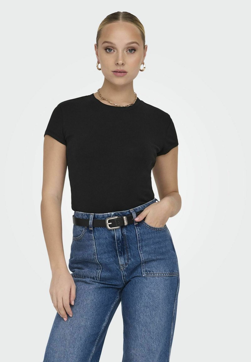 T-shirt nera a maniche corte realizzata in tessuto morbido, abbinata a jeans in denim blu a vita alta e una cintura nera con fibbia argentata.